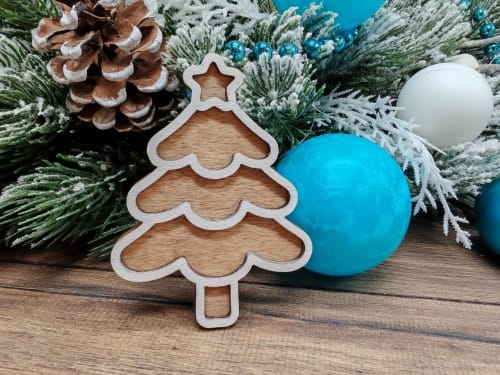 Free 3D layered laser cut wooden Christmas tree ornament in a wavy gingerbread style, displayed as a finished craft project on a rustic background for freecutcrafts.