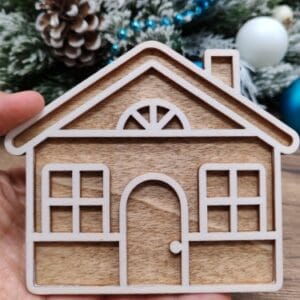 Finished 3D layered wooden gingerbread house Christmas tree ornament painted white with a dark stained wood backing layer.