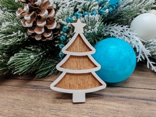 Finished 3D layered wooden gingerbread Christmas tree ornament with a star on top, painted white with a dark stained backing layer.