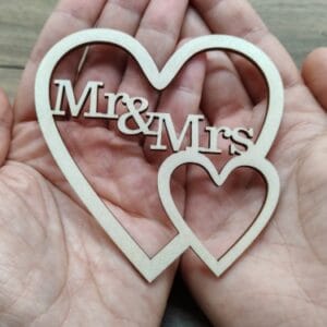 Wooden interlocking hearts wedding sign with Mr and Mrs text cutout held in hands, laser cut file template for Free Cut Crafts.